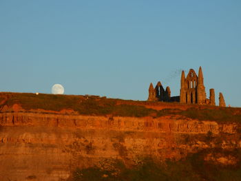 Low angle view of whitby abbey against clear sky at dusk