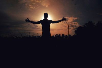 Silhouette man standing by tree against sky during sunset