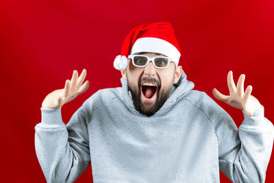 Portrait of young man wearing mask against red background