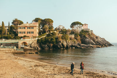 People at beach against clear sky