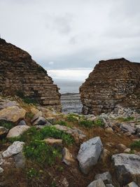 Rock formations on shore against sky