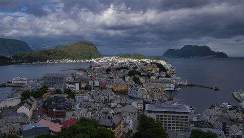 Aerial view of city by sea against sky