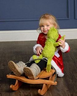 Smiling girl holding toy while sitting in basket