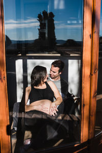 Young couple sitting in glass window