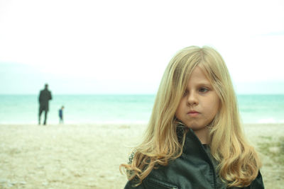 Portrait of young woman standing at beach