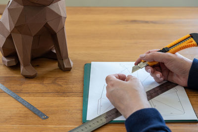 Cropped hand of man working on table