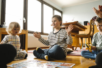 Boy having down syndrome completes jigsaw puzzle sitting with family in living room