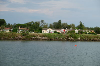 Scenic view of lake by building against sky