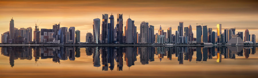 Panoramic shot of cityscape against sky during sunset