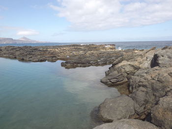 Rocks on shore against sky