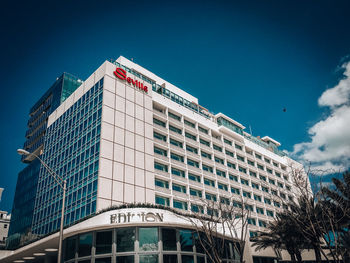 Low angle view of modern building against blue sky