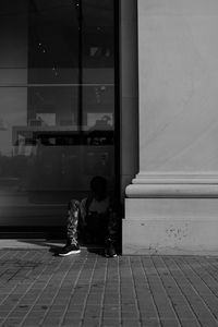 Rear view of couple sitting on glass window