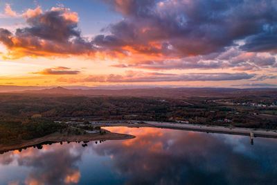 Drone aerial view of a lake reservoir of a dam with reflection on the water in sabugal, portugal