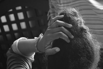 Cropped image of woman hand in hair at home