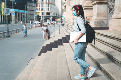 Full length of woman on footpath in city