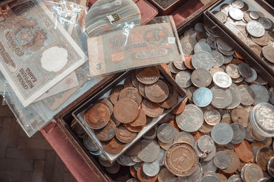 Old coins and paper money are lying on the edge of the table. top view