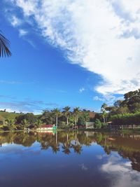 Scenic view of lake by trees and building against sky