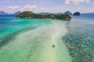 Drone view of couple at beach on sunny day