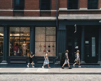 People walking on street against building