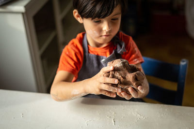 Close up of child hands kneading the dough