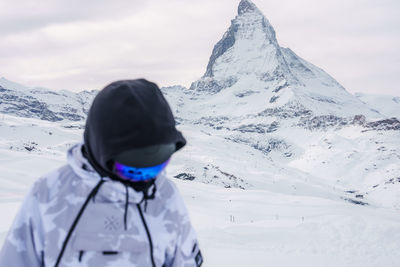 Rear view of woman skiing on snowcapped mountain