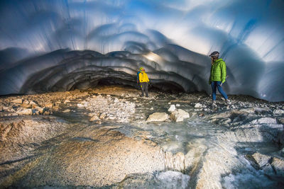 Adventurous couple exploring an ice cave.