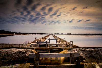 Built structure on sea against sky during sunset