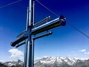 Low angle view of snowcapped mountains against clear blue sky