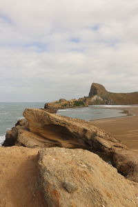 Rocks on beach against sky