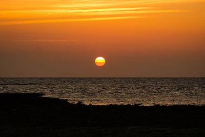 Scenic view of sea against orange sky