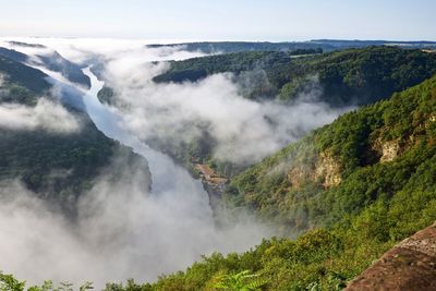 Scenic view of river amidst mountains against sky