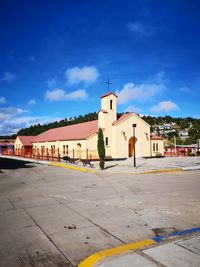 View of buildings in city against blue sky