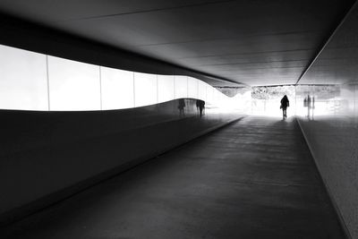 Rear view of person walking in tunnel