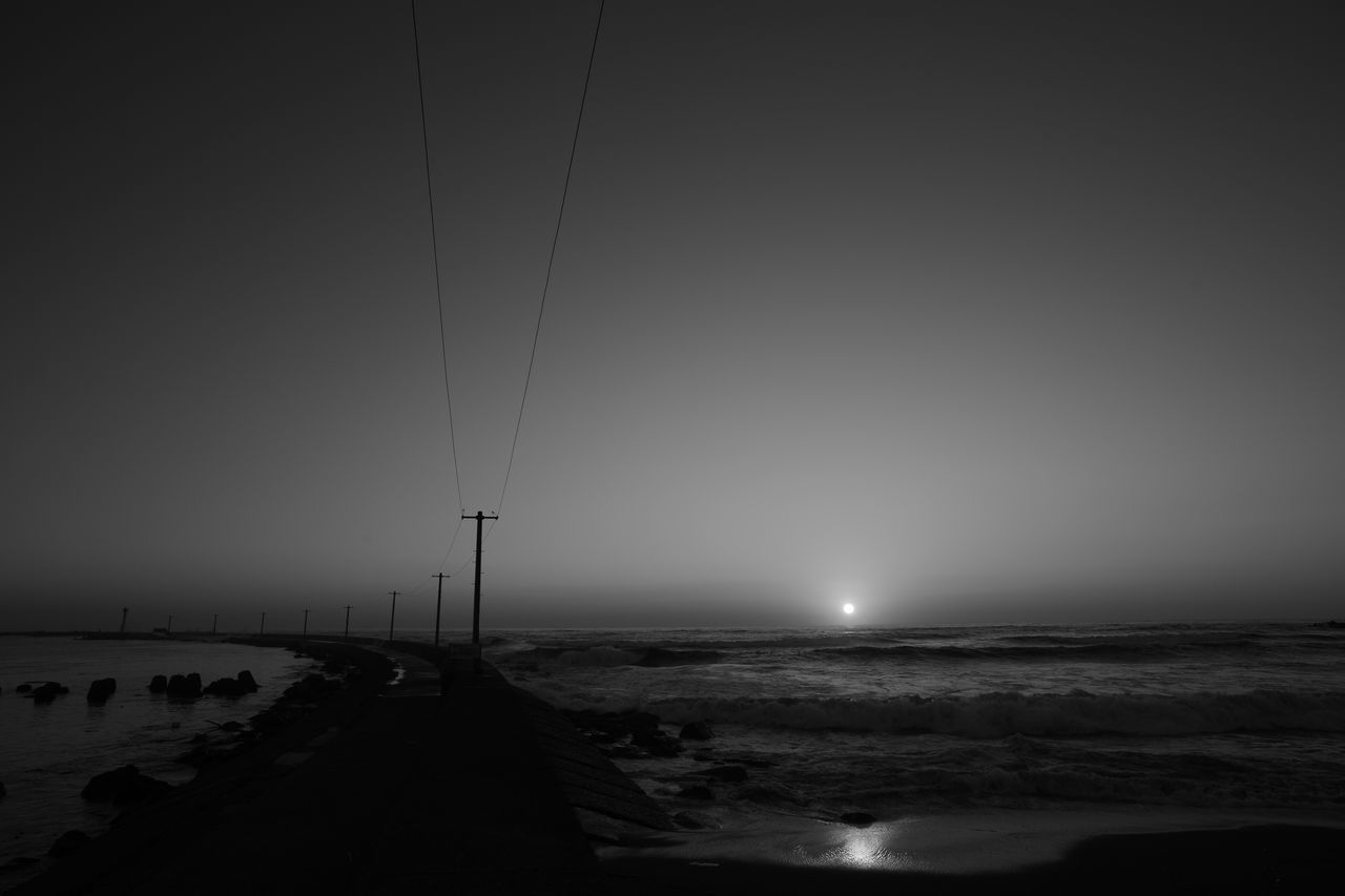 sea, horizon over water, water, clear sky, copy space, beach, tranquil scene, scenics, tranquility, beauty in nature, nature, shore, silhouette, idyllic, remote, outdoors, non-urban scene, street light, dusk, coastline