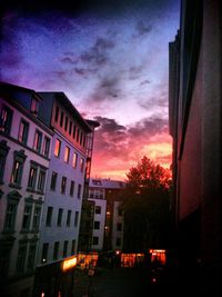 Silhouette of buildings against cloudy sky at sunset