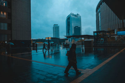Man walking on street in city during rainy season