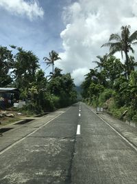 Road amidst trees against sky