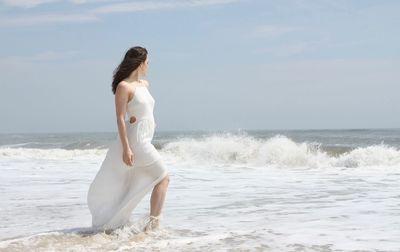 Woman standing on beach against clear sky