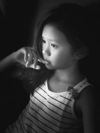 Close-up of thoughtful girl sitting in darkroom