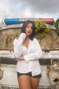 Portrait of woman standing against car