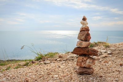 Rocks on sea shore against sky