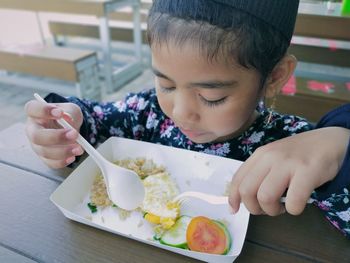 Cute girl holding meal on table