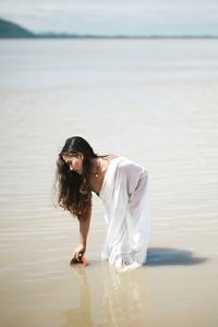 Woman with arms raised on beach