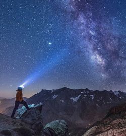 Man standing on rock against star field