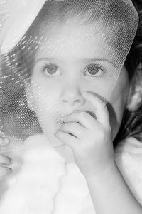 Close-up portrait of young woman covering face with hand