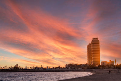 Sunset over barceloneta beach in barcelona, spain, during winter with cloudy sky. calm and peaceful 