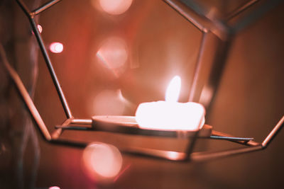 Close-up of illuminated tea light candles on table