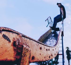 Low angle view of rusty metal against sky