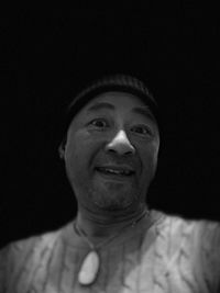 Portrait of young man against black background