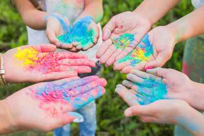 Close-up of hands holding multi colored people